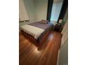 Comfortable bedroom featuring a bed with wooden drawers, a striped blanket, and hardwood floors at 1082 Geneva St, Aurora, CO 80010