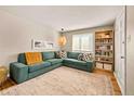 Inviting living room featuring a large sectional sofa, stylish decor, and natural light from the window at 871 Quebec St, Denver, CO 80220