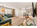 Open-concept living area with hardwood floors, modern furniture, and a dining space with ample natural light at 871 Quebec St, Denver, CO 80220