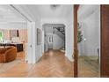 Elegant foyer with herringbone wood floors, staircase, and open access to living areas at 1500 E 7Th Ave, Denver, CO 80218