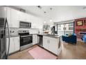 Bright modern kitchen featuring stainless steel appliances, white subway tile, and breakfast bar area at 1898 S Bannock St # 202, Denver, CO 80223