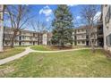 Scenic view of the condo buildings with green lawn, walkways, and mature trees creating a tranquil environment at 5995 E Iliff Ave # 308, Denver, CO 80222