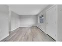 Spacious living room featuring new laminate flooring, fresh paint, and natural light from the large window at 5995 E Iliff Ave # 308, Denver, CO 80222