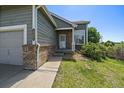 View of the front entrance featuring brick accents and well-maintained landscaping at 19688 E Lasalle Dr, Aurora, CO 80013