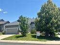Well-kept home with mature trees, green lawn, and a 'For Sale' sign, located on a quiet street at 19688 E Lasalle Dr, Aurora, CO 80013