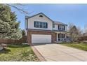Traditional two-story home boasting brick and siding exterior, complemented by a manicured lawn and driveway at 9456 Bexley Dr, Highlands Ranch, CO 80126