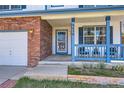 Close-up of the home's inviting front porch with blue railings and well-kept landscaping details at 9456 Bexley Dr, Highlands Ranch, CO 80126