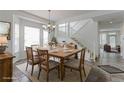 Dining room boasts a large table, a view of the staircase, and natural light from the large windows at 2631 E 136Th Pl, Thornton, CO 80602