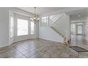 Bright living room boasting tiled floors, staircase, and ample natural light from large windows at 2631 E 136Th Pl, Thornton, CO 80602