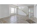 Bright living room boasting tiled floors, staircase, and ample natural light from large windows at 2631 E 136Th Pl, Thornton, CO 80602