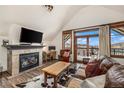 Cozy living room with fireplace, wood floors, and balcony access at 505 S Main St # 2207, Breckenridge, CO 80424