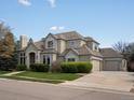 Stunning home with a 3-car garage, lush green lawn, and manicured shrubs at 5700 S Benton Cir, Littleton, CO 80123