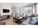 Comfortable living room with a large TV, wood floors, and access to an outdoor patio at 4265 E Iliff Ave # 1, Denver, CO 80222