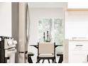 Bright dining area with a modern table, chairs, and natural light from the large window at 1361 W Custer Pl, Denver, CO 80223