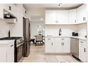 Modern kitchen with white cabinets, stainless steel appliances, and a view into the dining area at 1361 W Custer Pl, Denver, CO 80223
