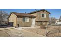 Exterior view featuring a two-story home with neutral siding and a gravel front yard at 7611 Fernando Rd, Denver, CO 80221