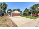 Charming single-story home featuring a large garage, well-maintained lawn, and colorful flower beds at 3735 S Lewiston St, Aurora, CO 80013
