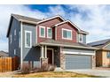 Two-story home showcasing gray exterior, red accents, stone trim, and a two-car garage at 6707 6Th St, Frederick, CO 80530