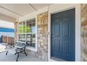 Inviting front porch featuring stone accents, a bench, and a blue front door at 6833 E 115Th Ave, Thornton, CO 80233