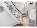 Light filled foyer with soaring ceilings, wood floors, and curved staircase at 9745 Hummingbird Pl, Littleton, CO 80125