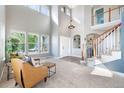 Bright living room with soaring ceilings, many windows, and neutral carpet at 9745 Hummingbird Pl, Littleton, CO 80125
