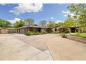 Spacious driveway with three-car garage and landscaping, with solar panels, providing ample parking and curb appeal at 10380 W Warren Ave, Lakewood, CO 80227