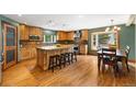 Well-lit kitchen with wood cabinets, granite counters, large center island with seating, and stainless steel appliances at 10380 W Warren Ave, Lakewood, CO 80227