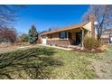 Lovely brick home with a well-manicured front yard and an attached garage on a sunny day at 620 Newport St, Denver, CO 80220