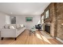 Sun-lit living room features hardwood floors, brick fireplace, and neutral decor at 620 Newport St, Denver, CO 80220