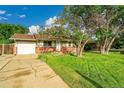 Single-story home with a lush front lawn, mature trees, and an attached garage at 1030 Kohl St, Broomfield, CO 80020