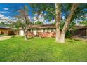 Inviting single-story home with well-kept lawn, mature trees, and brick accents at 1030 Kohl St, Broomfield, CO 80020