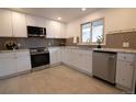 Modern kitchen with white cabinets, stainless steel appliances, tile backsplash, and ample counter space at 2300 S Krameria St, Denver, CO 80222