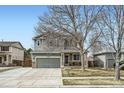 Inviting two-story house with a front-facing two car garage, set against a clear blue sky at 10529 Vaughn Way, Commerce City, CO 80022