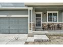 Welcoming front porch featuring a seating area, stonework accents and a view of the garage at 10529 Vaughn Way, Commerce City, CO 80022