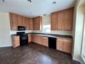Well-lit kitchen featuring oak cabinetry, granite countertops, and modern black appliances at 7811 St Vrain Dr # 68, Frederick, CO 80530