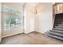 Bright foyer features tile flooring, a staircase to the upper level, and a large window at 9661 Autumnwood Pl, Highlands Ranch, CO 80129