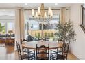 Bright dining room with modern chandelier and sliding glass doors to the backyard at 14423 Shasta Daisy Ln, Parker, CO 80134