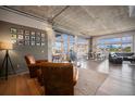 Open living room area with hardwood flooring, many windows, and exposed concrete ceiling at 1925 W 32Nd Ave # 404, Denver, CO 80211