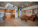 Comfortable living room area featuring hardwood floors, exposed concrete ceiling and decorative lighting at 1925 W 32Nd Ave # 404, Denver, CO 80211