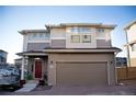 Two-story home features a tan-colored exterior, an attached garage, and a brick-paved driveway at 2848 Merry Rest Way, Castle Rock, CO 80109