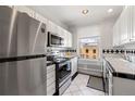 Efficient kitchen featuring stainless steel appliances, white cabinetry, and a window overlooking the exterior at 1475 N Humboldt St # 20, Denver, CO 80218