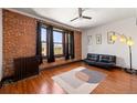 Spacious living room features exposed brick wall, hardwood floors, and modern ceiling fan at 1475 N Humboldt St # 20, Denver, CO 80218
