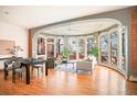 Open floor plan combining the living and dining areas, featuring large windows and hardwood floors at 3249 W Fairview Pl # 106, Denver, CO 80211