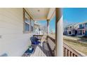 Cozy front porch showcasing wooden decking, a charming wicker chair, and views of the neighborhood at 4523 Crestone Peak St, Brighton, CO 80601