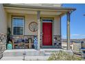 Inviting front porch with stone accents, decorative art and outdoor seating at 5837 High Timber Cir, Castle Rock, CO 80104