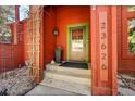 Inviting front porch with a green door frame, potted plants, and clear numbering at 23626 Genesee Village Rd, Golden, CO 80401