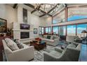 Inviting living room with a stone fireplace, vaulted ceilings, and breathtaking city views at 703 Emberglow Ln, Highlands Ranch, CO 80126
