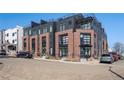 Modern multi-story brick apartment building featuring large windows and a dark metal facade at 1242 Yates St # U2, Denver, CO 80204