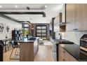 Modern kitchen featuring wooden cabinets, black countertops, island and unique industrial elements at 1242 Yates St # U2, Denver, CO 80204