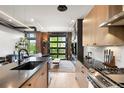 Stylish kitchen with modern appliances, wood cabinets, and a view of the living area through a glass garage door at 1242 Yates St # U2, Denver, CO 80204